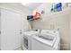 Functional laundry room with washer, dryer, and storage shelves at 2563 Firethorn Ct, Gastonia, NC 28056