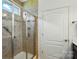 Tiled shower with glass door, grab bar, and a built-in niche for toiletries at 258 Cherrytree Dr, Fort Mill, SC 29715