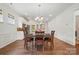 Dining room featuring hardwood floors, chandelier, and an adjacent modern kitchen at 258 Cherrytree Dr, Fort Mill, SC 29715