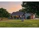 Inviting brick and stone home with a charming well and manicured lawn at sunset at 2843 Startown Rd, Lincolnton, NC 28092