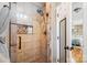 Tiled shower featuring stone accents, recessed shelving, and a glass door at 2843 Startown Rd, Lincolnton, NC 28092