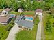 Expansive aerial view of a home with a pool, detached garage, green lawn and mature trees at 2908 Dylan Nw Pl, Concord, NC 28027