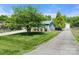 Well-manicured lawn and driveway leading to a home with mature trees in the yard at 2908 Dylan Nw Pl, Concord, NC 28027