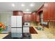 Modern kitchen with stainless steel appliances, granite countertops, and cherry wood cabinets at 2908 Dylan Nw Pl, Concord, NC 28027