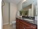 Bathroom featuring a granite countertop, wood cabinets, decorative plant and shower at 300 W 5Th St # 723, Charlotte, NC 28202