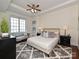 Cozy main bedroom with a sitting area, large window, and a ceiling fan at 300 W 5Th St # 723, Charlotte, NC 28202