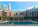 A serene swimming pool area surrounded by comfortable lounge chairs and lush landscaping overlooking the city skyline at 300 W 5Th St # 723, Charlotte, NC 28202