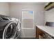 Modern laundry room with sleek washer and dryer, bright window, and counter space at 3092 Riker St, Clover, SC 29710