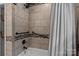 Tiled bathtub and shower with a grab bar for accessibility and safety at 312 Walton Dr, Statesville, NC 28625