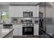 Well-equipped kitchen featuring white cabinets, stainless steel appliances, and granite countertops at 312 Walton Dr, Statesville, NC 28625