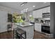 Bright and modern kitchen with stainless steel appliances, a center island, and a view to the backyard at 312 Walton Dr, Statesville, NC 28625