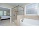 Bright bathroom featuring a glass shower, soaking tub, and neutral tile at 317 Annatto Way, Tega Cay, SC 29708