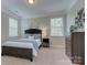 Bedroom features a Queen bed with blue bedding, two windows and neutral walls at 317 Annatto Way, Tega Cay, SC 29708