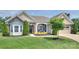 Charming brick and siding home with manicured front lawn, mature trees, and inviting front entrance at 317 Annatto Way, Tega Cay, SC 29708