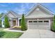 Garage door with brick accents and manicured landscaping at 317 Annatto Way, Tega Cay, SC 29708