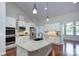 Well-lit kitchen features an island, stainless steel appliances, and white cabinetry at 317 Annatto Way, Tega Cay, SC 29708