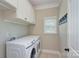 Laundry room featuring modern appliances, upper cabinets, and a window at 317 Annatto Way, Tega Cay, SC 29708
