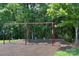 Community playground with swings, surrounded by mature trees, providing a shaded and safe play area at 317 Annatto Way, Tega Cay, SC 29708