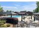 Community pool with spacious deck, sun loungers, shaded seating, and clubhouse in the background at 317 Annatto Way, Tega Cay, SC 29708