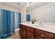 Well-lit bathroom boasts double sink vanity, updated fixtures and blue shower curtain at 3512 Gibbon Terrace Ct, Charlotte, NC 28269