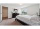 Bright bedroom features neutral carpet, window view, dark wood furnishings and walk-in closet at 3512 Gibbon Terrace Ct, Charlotte, NC 28269