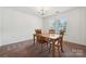 A cozy dining room with a wood table, four chairs, a chandelier, and natural light from the large window at 3512 Gibbon Terrace Ct, Charlotte, NC 28269