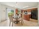 Cozy kitchen and dining area with wood cabinets, a kitchen island, and a view to the outdoors through sliding glass doors at 3512 Gibbon Terrace Ct, Charlotte, NC 28269