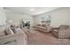 Bright living room with neutral tones, stylish furniture, and seamless connection to the outdoors through large windows at 3512 Gibbon Terrace Ct, Charlotte, NC 28269