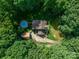 Stunning aerial view of a private home with a pool, surrounded by lush trees, creating a peaceful retreat at 3513 Briarcliff Acres Dr, Lincolnton, NC 28092