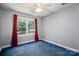 Cozy bedroom features gray walls, blue carpeting, and a large window at 3513 Briarcliff Acres Dr, Lincolnton, NC 28092