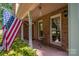 Inviting front porch with American flag, brick columns, and small table at 3513 Briarcliff Acres Dr, Lincolnton, NC 28092