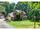 Picturesque two-story brick home with lush lawn, mature trees, and an inviting covered front porch at 3513 Briarcliff Acres Dr, Lincolnton, NC 28092