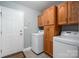 Functional laundry room with washer, dryer, and oak cabinetry at 3513 Briarcliff Acres Dr, Lincolnton, NC 28092