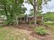 Charming brick home featuring a wooden deck and screened-in porch, nestled in a lush, tree-filled backyard at 4000 Chandworth Rd, Charlotte, NC 28210