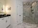 Bathroom with granite vanity and large glass-enclosed shower with marble tile and a bench at 4000 Chandworth Rd, Charlotte, NC 28210