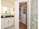 Bathroom vanity next to a bi-fold closet and marble tiled shower at 4000 Chandworth Rd, Charlotte, NC 28210