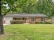 Charming brick home featuring a well-maintained lawn and a manicured shrub in front at 4000 Chandworth Rd, Charlotte, NC 28210