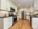 Well-lit kitchen features stainless steel appliances, black countertops, white cabinets, and hardwood floors at 4000 Chandworth Rd, Charlotte, NC 28210