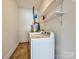 Functional laundry room featuring a white washer and dryer with utility shelving for added storage at 4000 Chandworth Rd, Charlotte, NC 28210