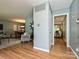 Open-concept living room with hardwood floors and blue-grey walls leads to dining and den at 4000 Chandworth Rd, Charlotte, NC 28210
