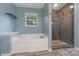Modern bathroom with a soaking tub, glass-enclosed shower, and a window offering bright, natural light at 4002 Paddle Wheel Ln, Indian Trail, NC 28079