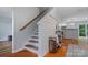 Elegant stairway with wooden banister and stylish wall paneling, leading to upper level at 4002 Paddle Wheel Ln, Indian Trail, NC 28079