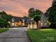 Stately brick home with a manicured lawn, a circular driveway, and a three-car garage at dusk at 4290 Barbrick St, Sherrills Ford, NC 28673