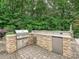 Outdoor kitchen with stainless steel appliances built into a stone counter and brick flooring at 4290 Barbrick St, Sherrills Ford, NC 28673