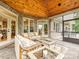 Covered outdoor patio with wicker sofas and marble coffee tables, ceiling fan, and doors leading to backyard at 4290 Barbrick St, Sherrills Ford, NC 28673