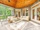 Covered outdoor patio with two sofas, coffee tables, a ceiling fan and a view of the green back yard at 4290 Barbrick St, Sherrills Ford, NC 28673