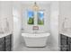 Elegant bathroom featuring a modern freestanding tub beneath a window with nature views and stylish chandelier at 435 Galbreath Ct # 128, Fort Mill, SC 29708