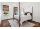 Bedroom with wood floors, neutral rug, four poster bed, and windows overlooking the front yard at 435 Galbreath Ct # 128, Fort Mill, SC 29708