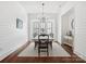 Dining room with wood floors, white ship lap walls, white table with black chairs, and elegant lighting fixture at 435 Galbreath Ct # 128, Fort Mill, SC 29708