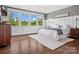 Spacious main bedroom with a large bed, hardwood floors, stylish decor, and lots of natural light from expansive windows at 435 Galbreath Ct # 128, Fort Mill, SC 29708